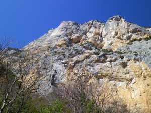 Paroi de l'Escalès - La Demande suit la fissure continue légèrement sur la gauche, longeant l’impressionnant pilier lisse, compact et blanc.
