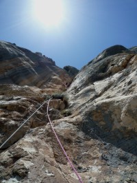 Sixième longueur en 6a+. Le trait dans le ciel n'est pas la traînée d'un avion mais une highline de 300 mètres...