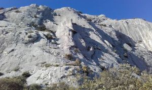 La falaise de Saint Ser - l'Ermitage. La ligne du Mathou est située entre ombre et soleil, dans une rampe évidente ascendante à gauche